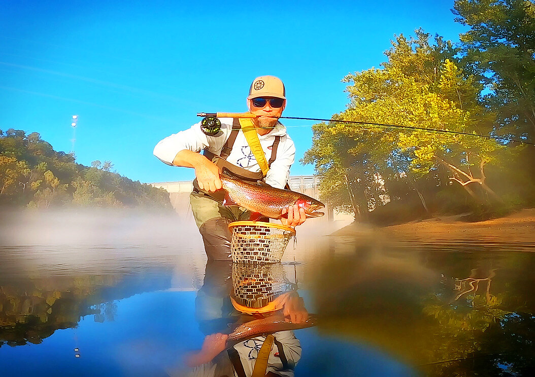 Guide holding a healthy rainbow trout on Lake Taneycomo