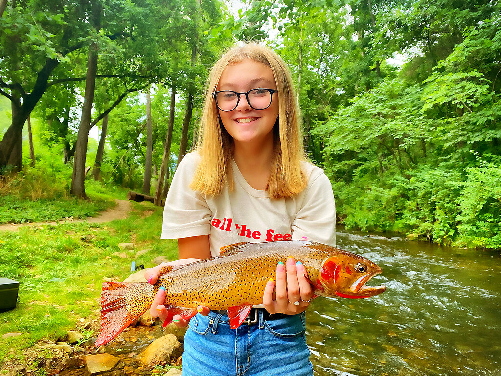 Young angler holding a large cutthroat trout